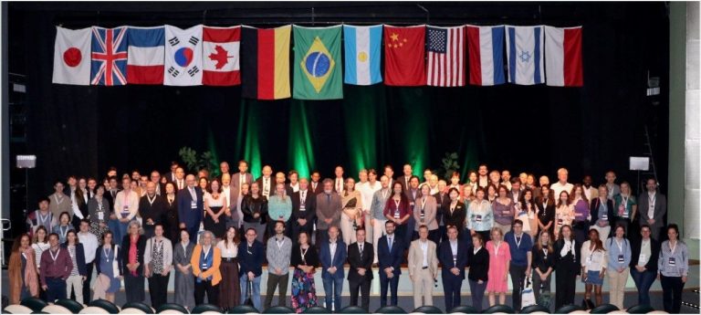 Delegates gather on a stage in front of multiple international flags